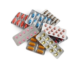 Pile of different pills in blister packs on white background