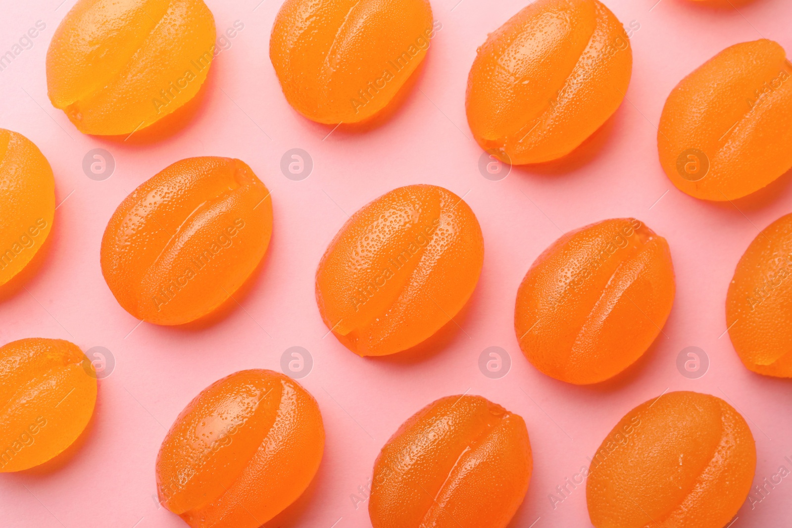 Photo of Delicious gummy candies on pink background, flat lay