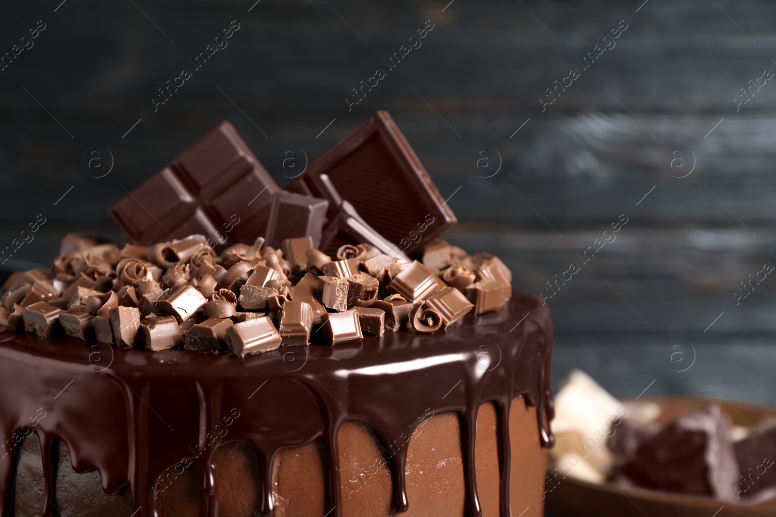 Photo of Freshly made delicious chocolate cake against black background, closeup