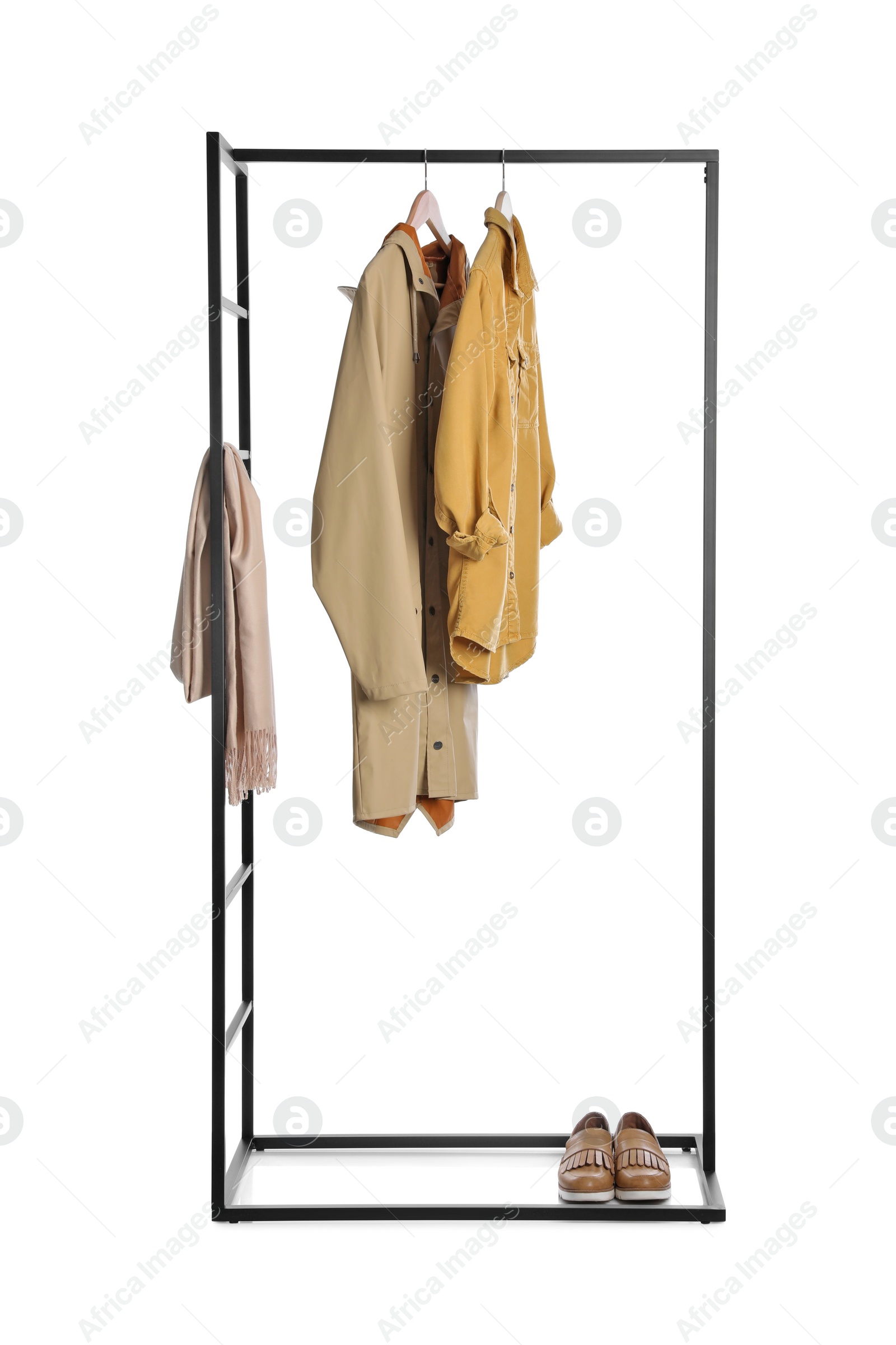 Photo of Stylish rack with clothes and shoes on white background