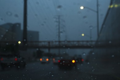 Road on rainy day, view through car window with water drops