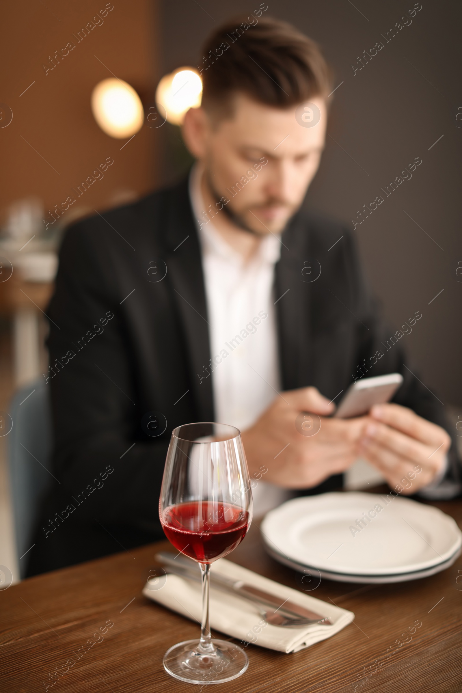 Photo of Man with glass of wine at table in restaurant