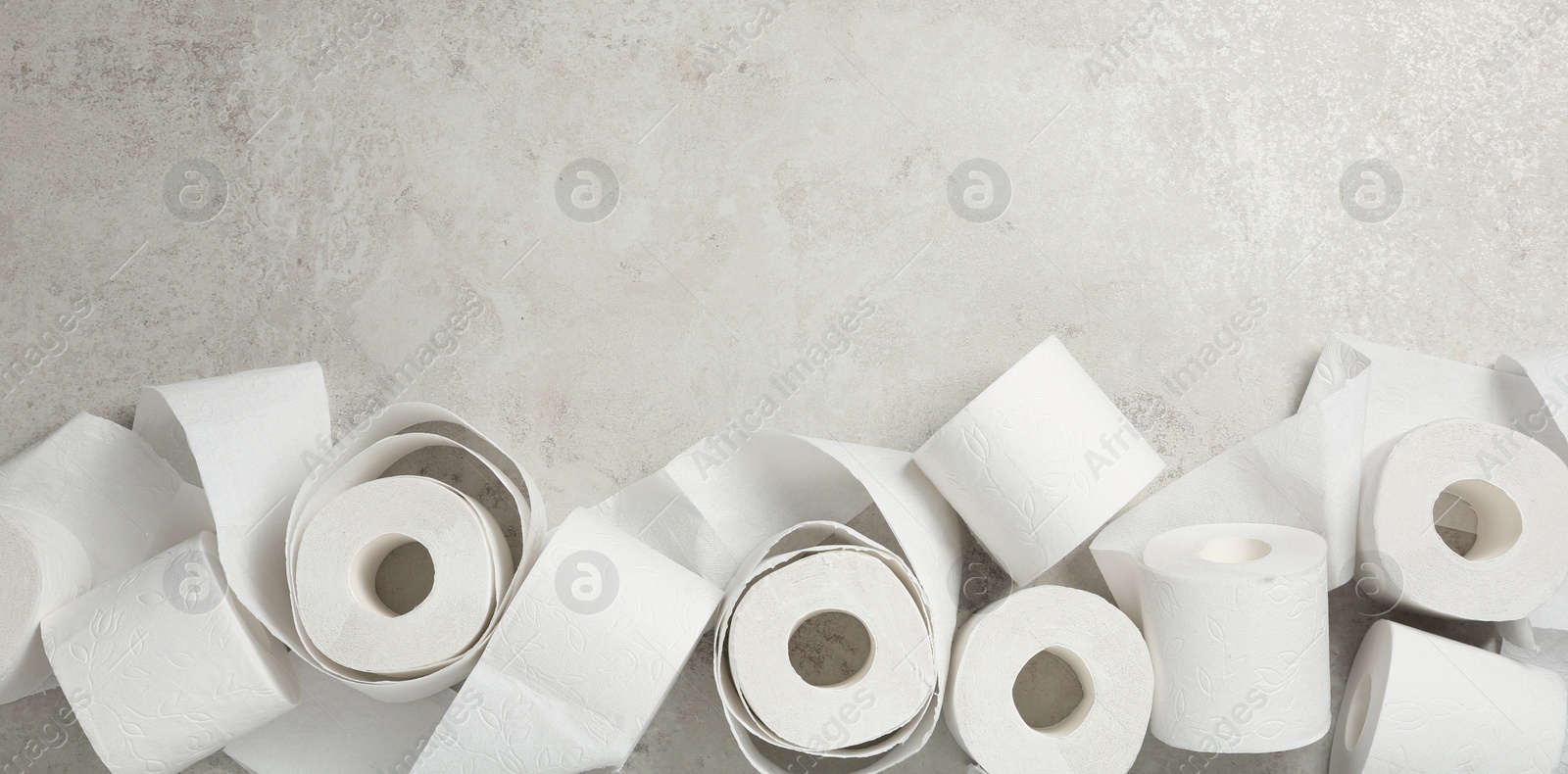 Photo of Flat lay composition with toilet paper on grey background. Space for text