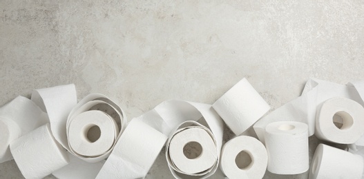 Flat lay composition with toilet paper on grey background. Space for text