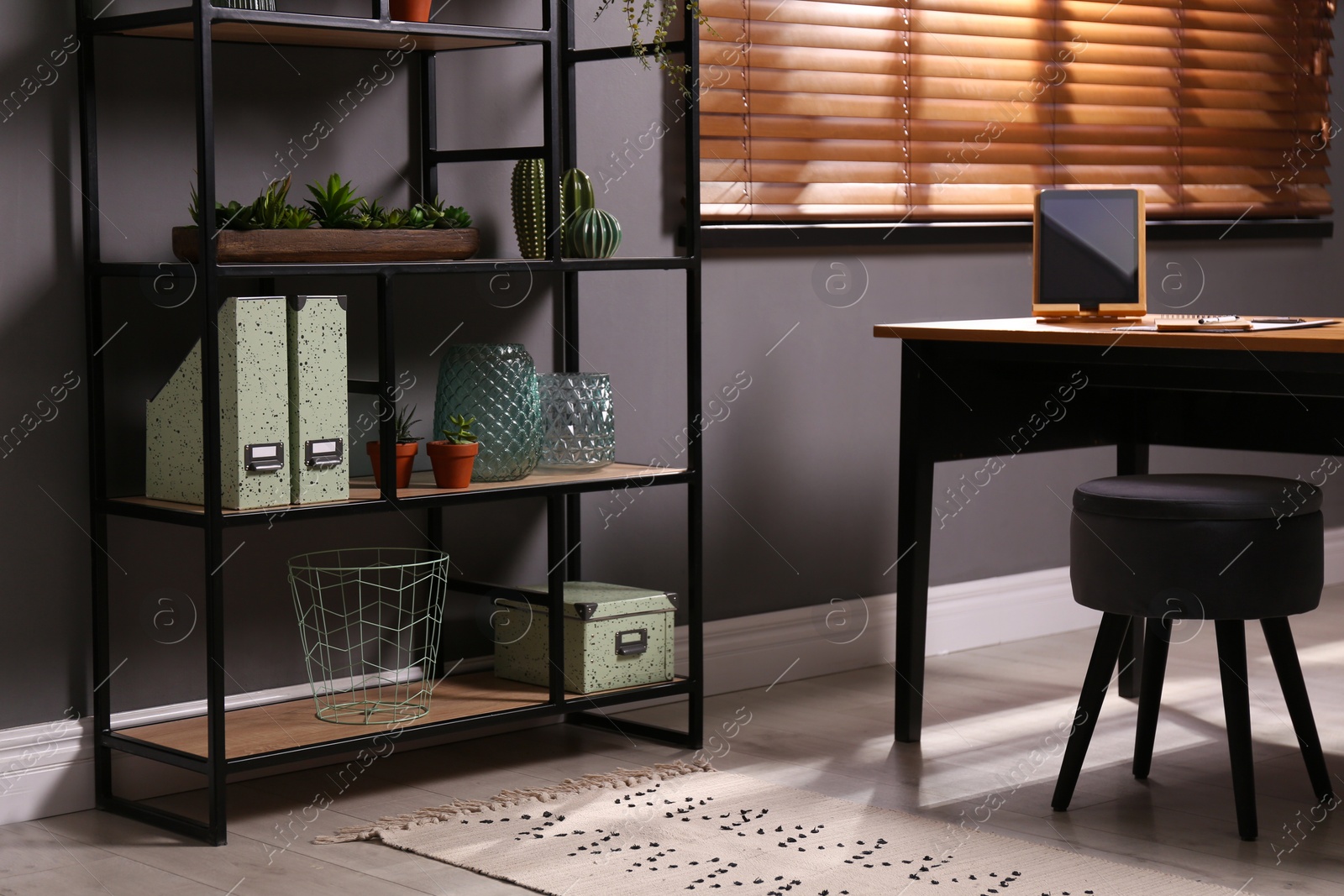 Photo of Stylish room with shelving and table. Interior design