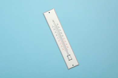 Photo of Weather thermometer on light blue background, top view