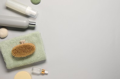 Bath accessories. Flat lay composition with personal care products on light grey background, space for text
