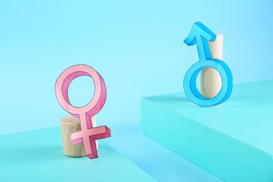 Photo of Gender pay gap. Male and female symbols on light blue background