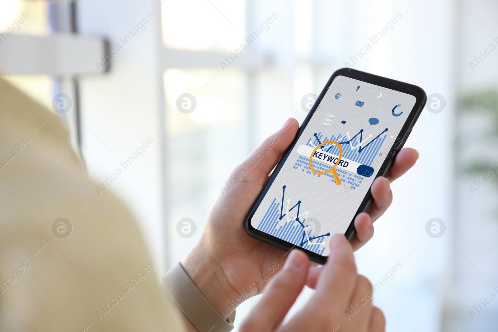 Image of Woman with smartphone searching for keywords indoors, closeup