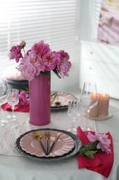 Photo of Beautiful table setting with pink peonies and burning candles