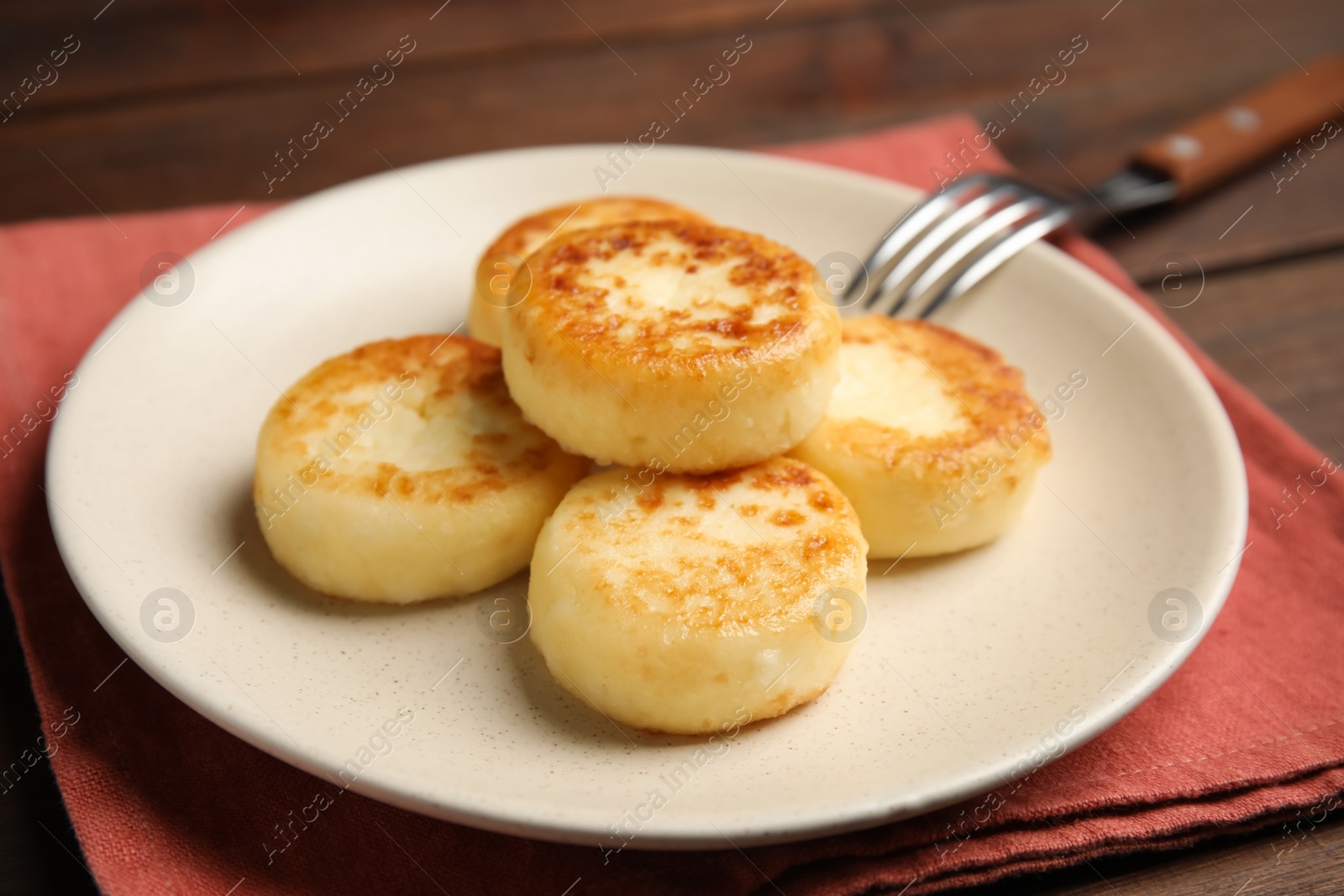 Photo of Delicious cottage cheese pancakes on wooden table