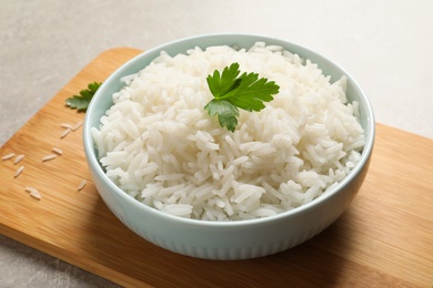 Bowl of delicious rice with parsley on table