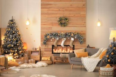 Photo of Stylish room interior with beautiful Christmas tree and decorative fireplace