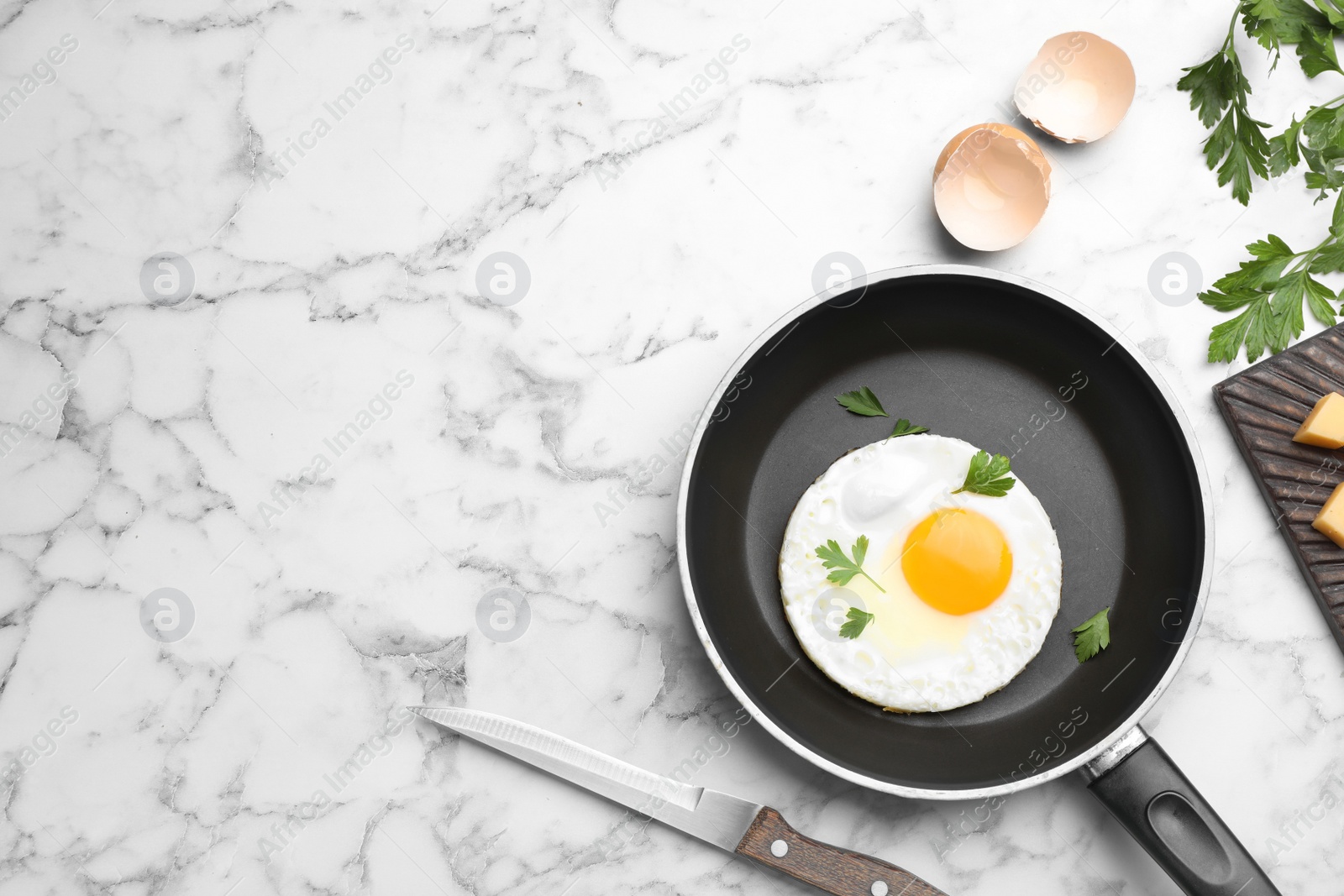 Photo of Pan with fried sunny side up egg served on table, flat lay with space for text