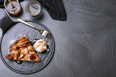 Slice of traditional apple pie with ice cream on grey table, flat lay. Space for text
