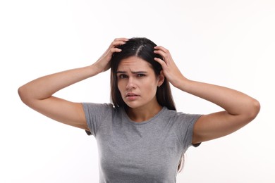 Photo of Emotional woman examining her hair and scalp on white background. Dandruff problem