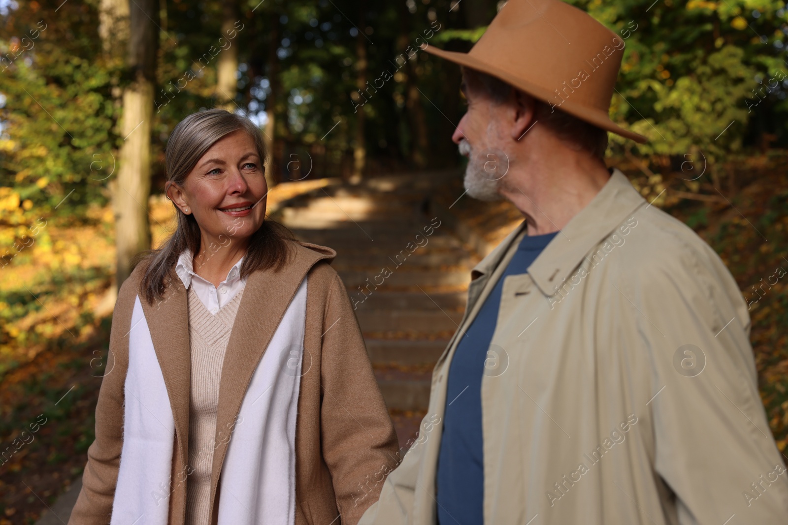 Photo of Affectionate senior couple walking in autumn park