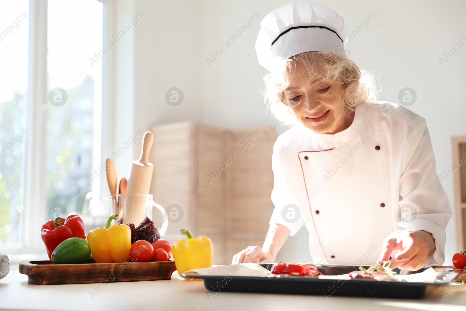 Photo of Professional female chef preparing meat in kitchen