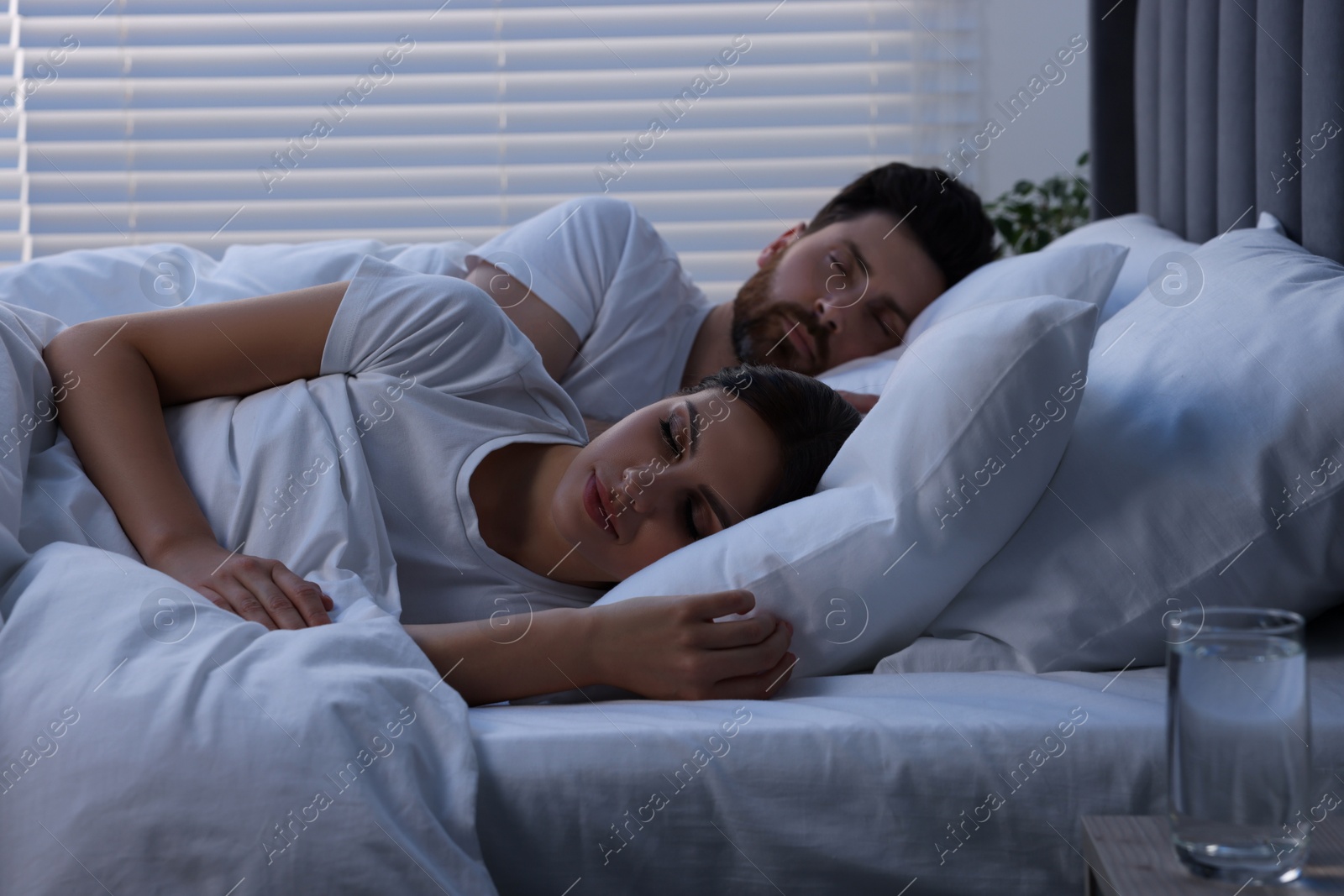 Photo of Lovely couple sleeping together in bed at night