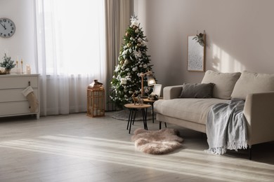 Festive room interior with stylish furniture and beautiful Christmas tree