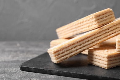Photo of Delicious cream wafers on grey table, closeup. Space for text