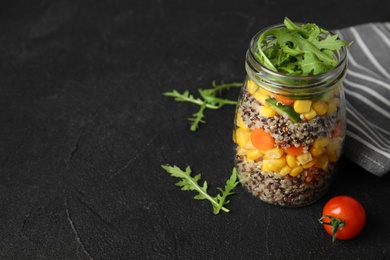 Photo of Jar with healthy quinoa salad and vegetables on table. Space for text