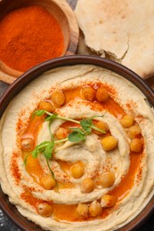 Delicious hummus with chickpeas and different ingredients on grey table, flat lay