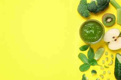 Photo of Delicious green juice and fresh ingredients on yellow background, flat lay. Space for text