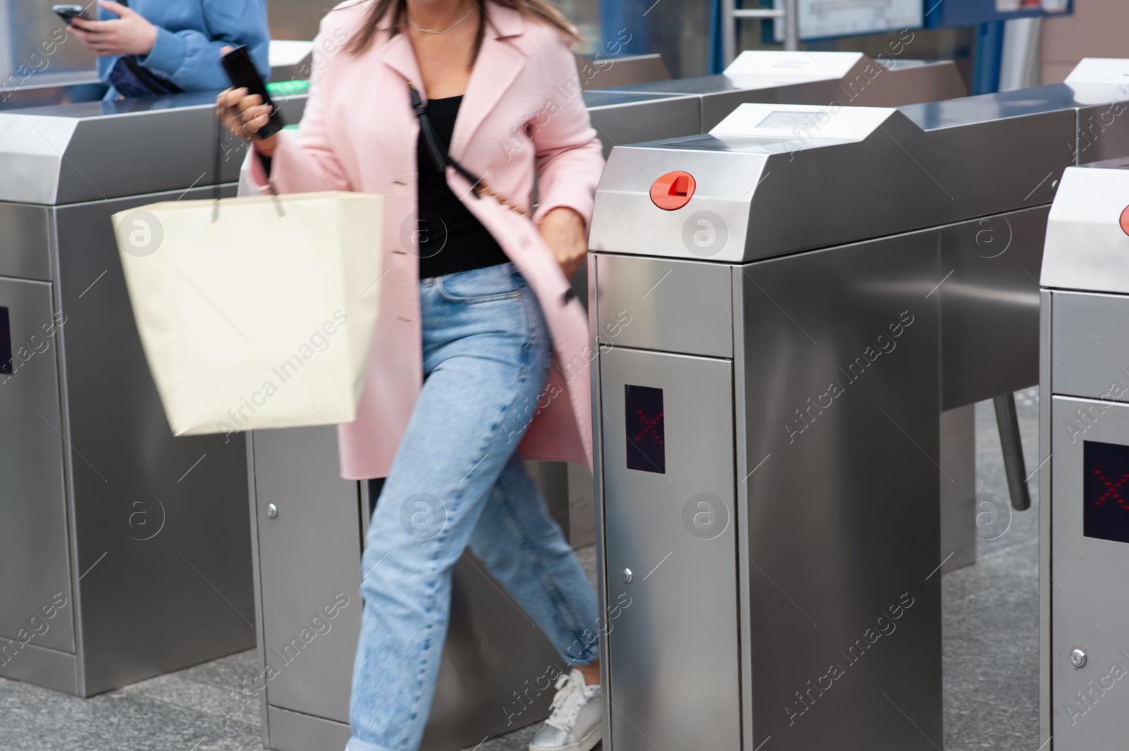 Photo of People passing turnstiles, closeup view. Fare collection system