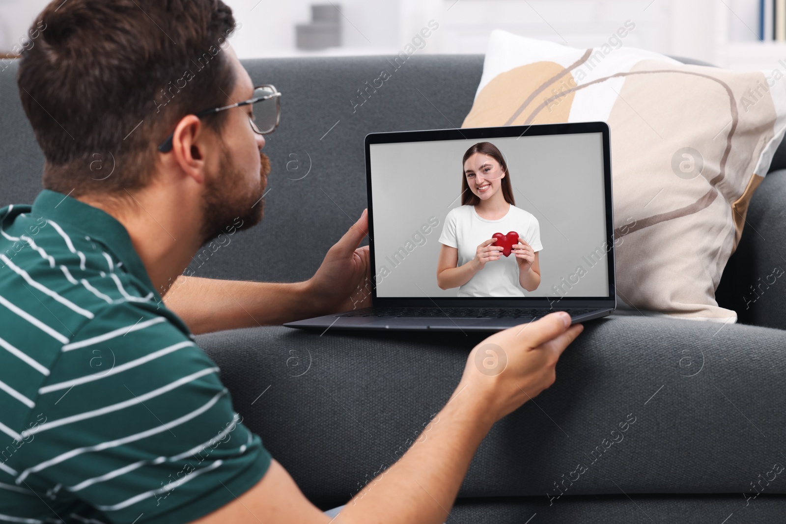 Image of Long distance love. Man having video chat with his girlfriend via laptop at home