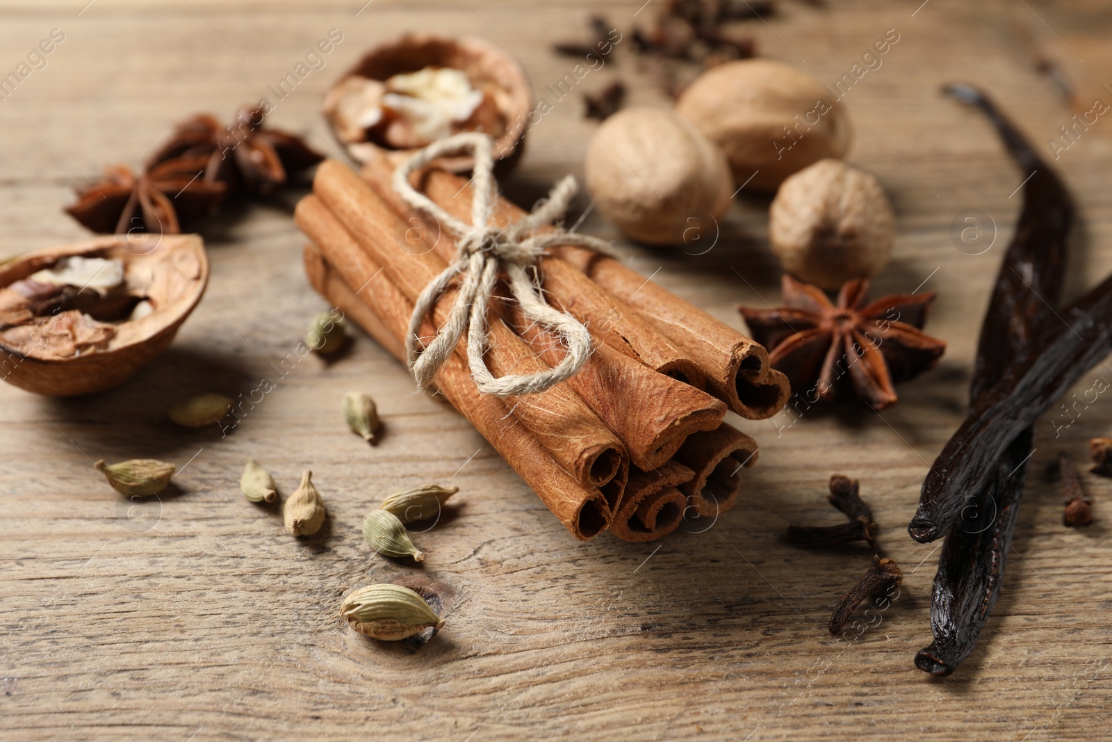 Photo of Different spices and nuts on wooden table, closeup