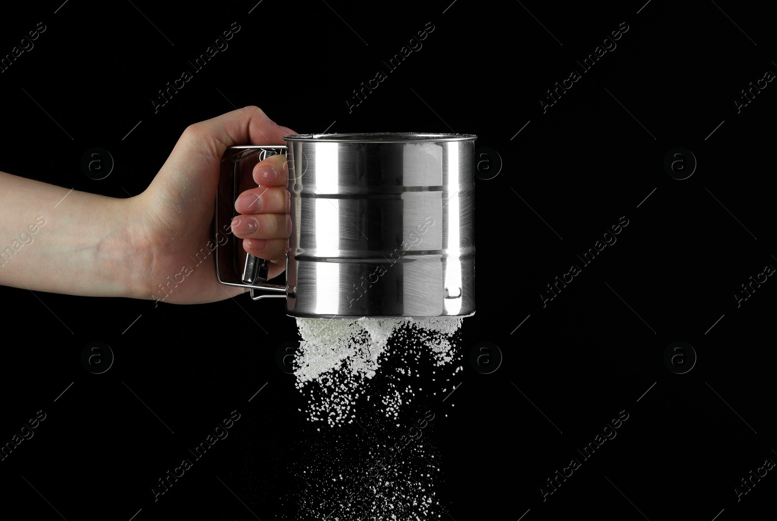 Photo of Woman sieving flour against black background, closeup. Space for text