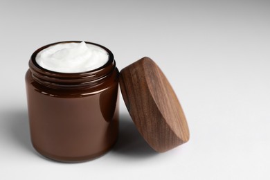 Photo of Glass jar of face cream on white table. Space for text