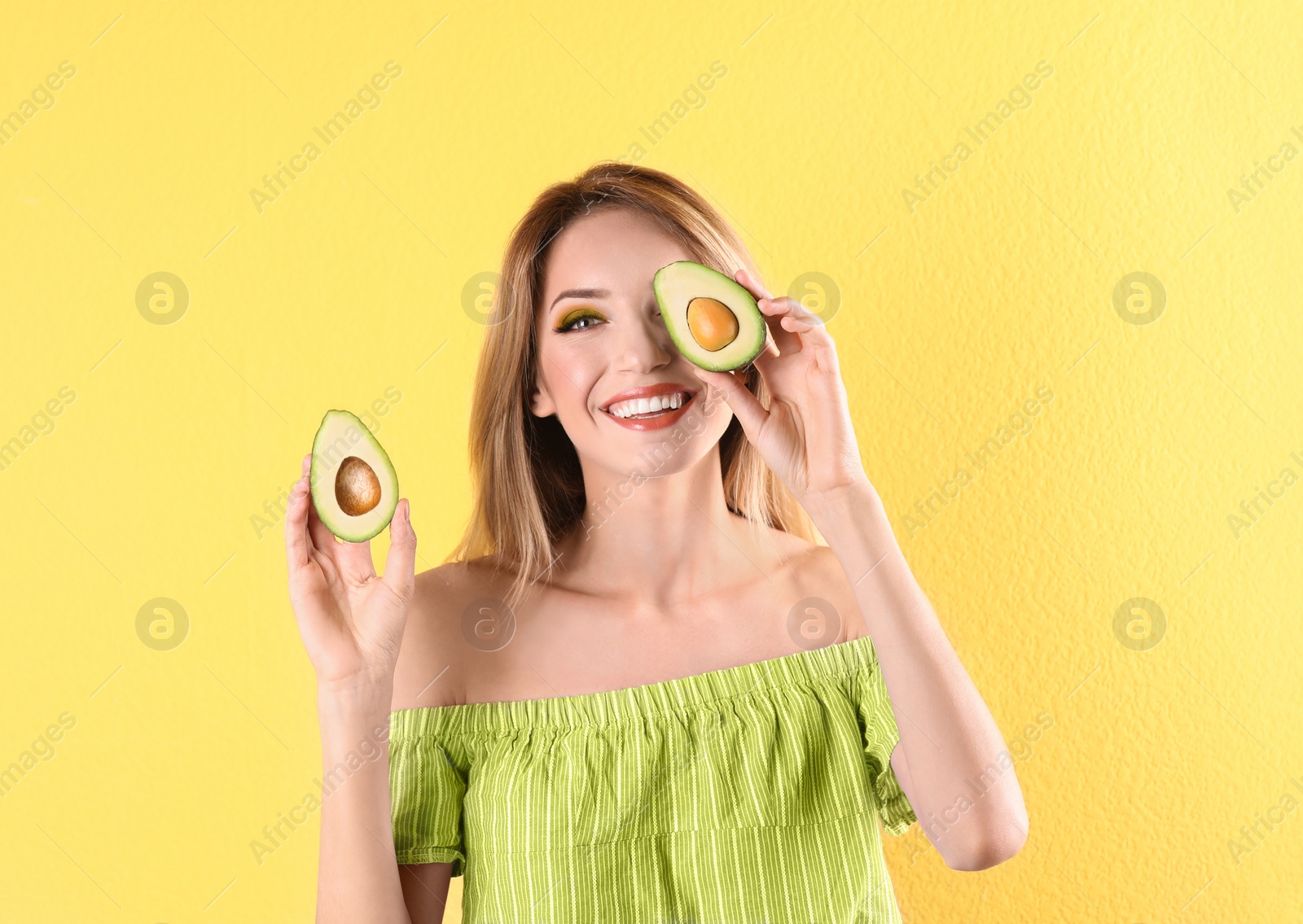 Photo of Portrait of young beautiful woman with ripe delicious avocado on color background