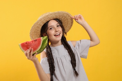 Photo of Cute little girl with watermelon on yellow background