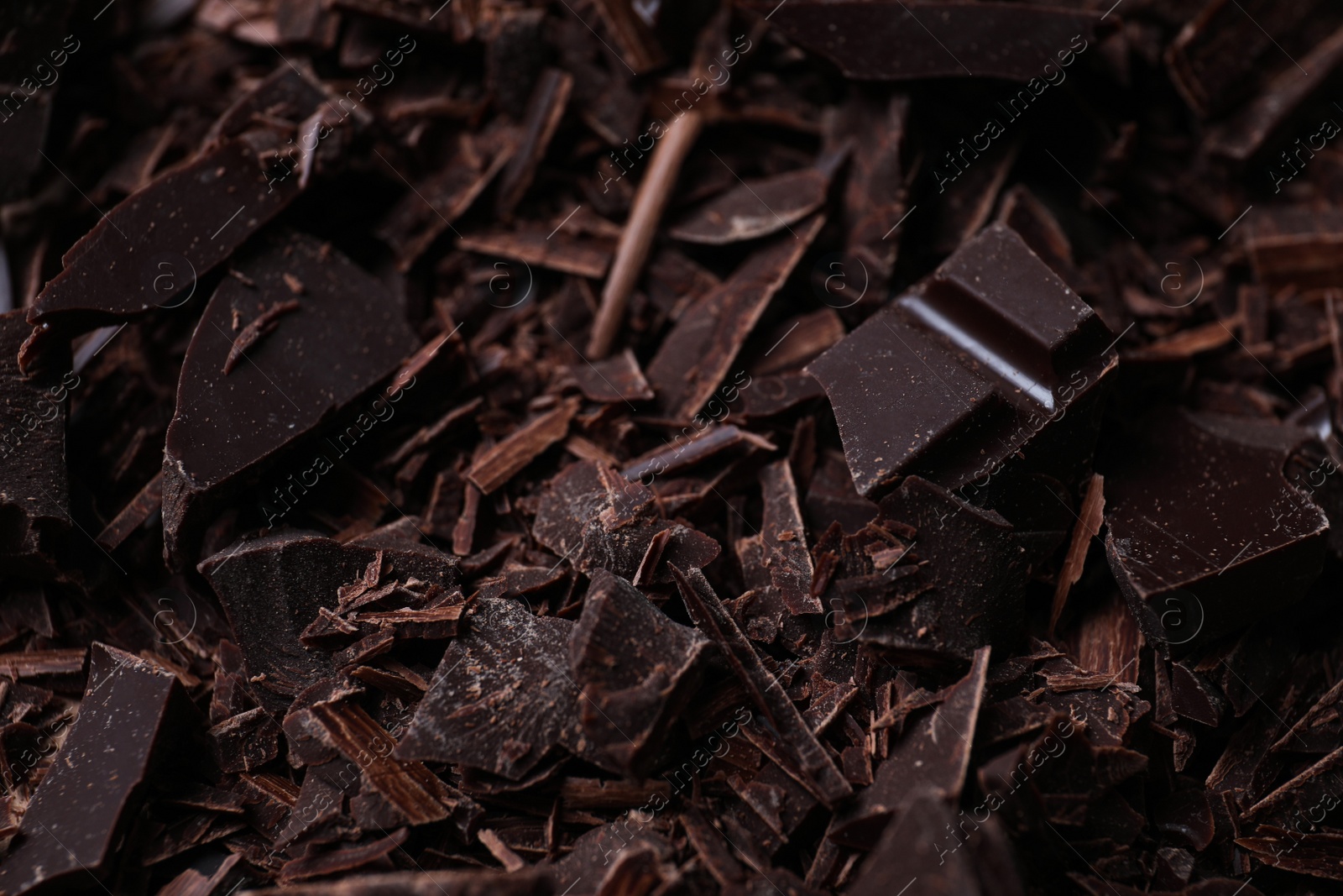 Photo of Tasty crushed dark chocolate as background, closeup