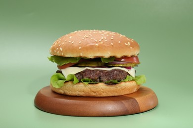 Photo of Burger with delicious patty on green background