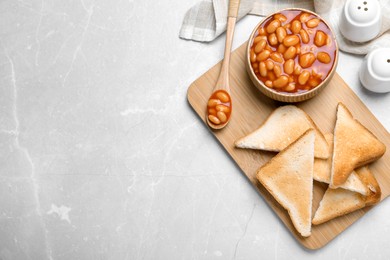 Toasts and delicious canned beans on white table, flat lay. Space for text