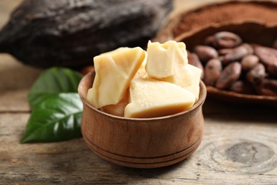 Photo of Organic cocoa butter on wooden table, closeup