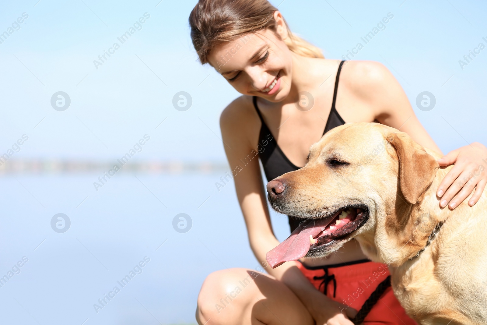 Photo of Young woman and her dog spending time together outdoors. Pet care