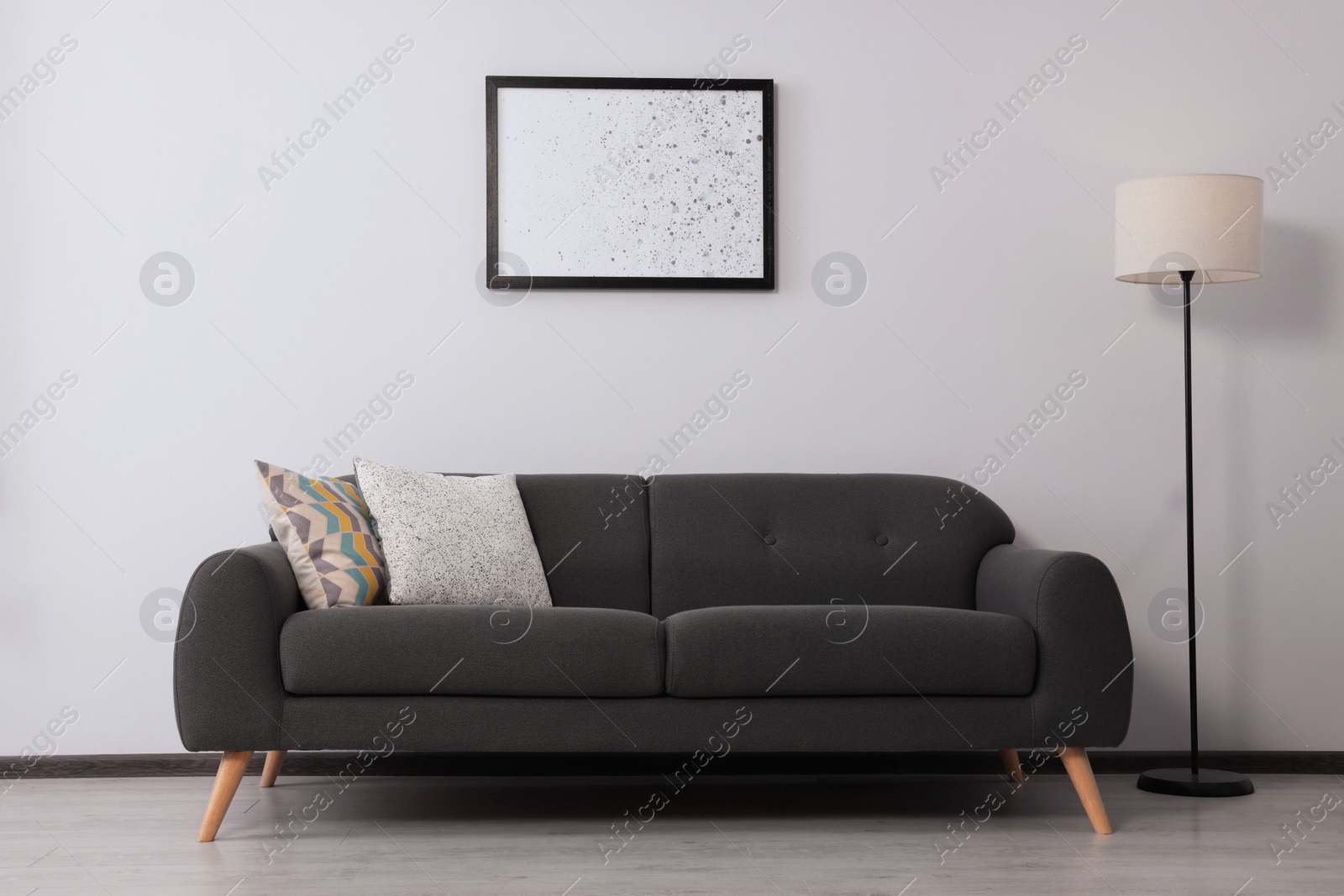 Photo of Stylish room interior with sofa and floor lamp