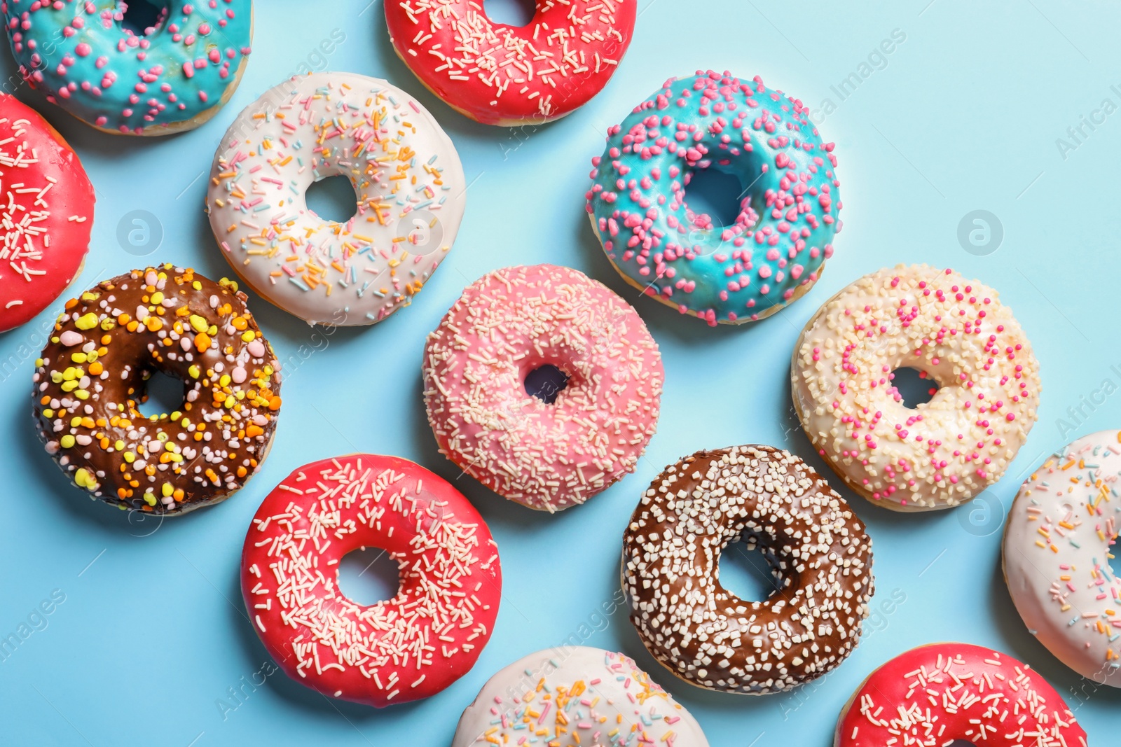 Photo of Delicious glazed doughnuts on color background, top view