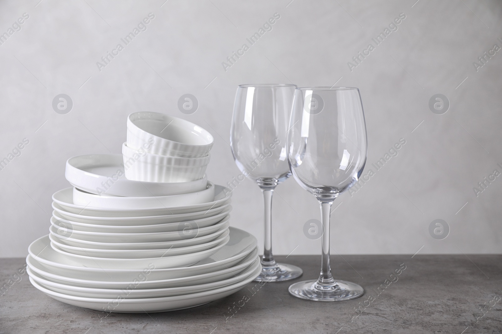 Photo of Set of clean dishware on grey table