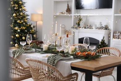 Photo of Christmas table setting with festive decor and dishware in living room