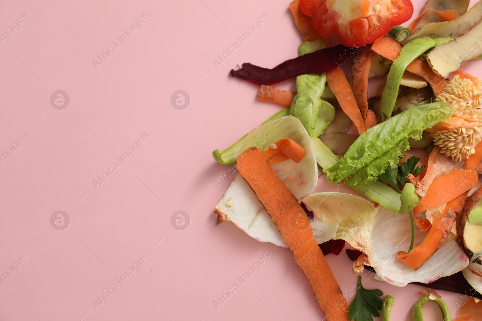 Photo of Peels of fresh vegetables on pink background, flat lay. Space for text