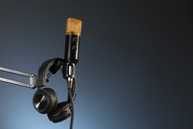 Photo of Stand with microphone and headphones on dark background, space for text. Sound recording and reinforcement