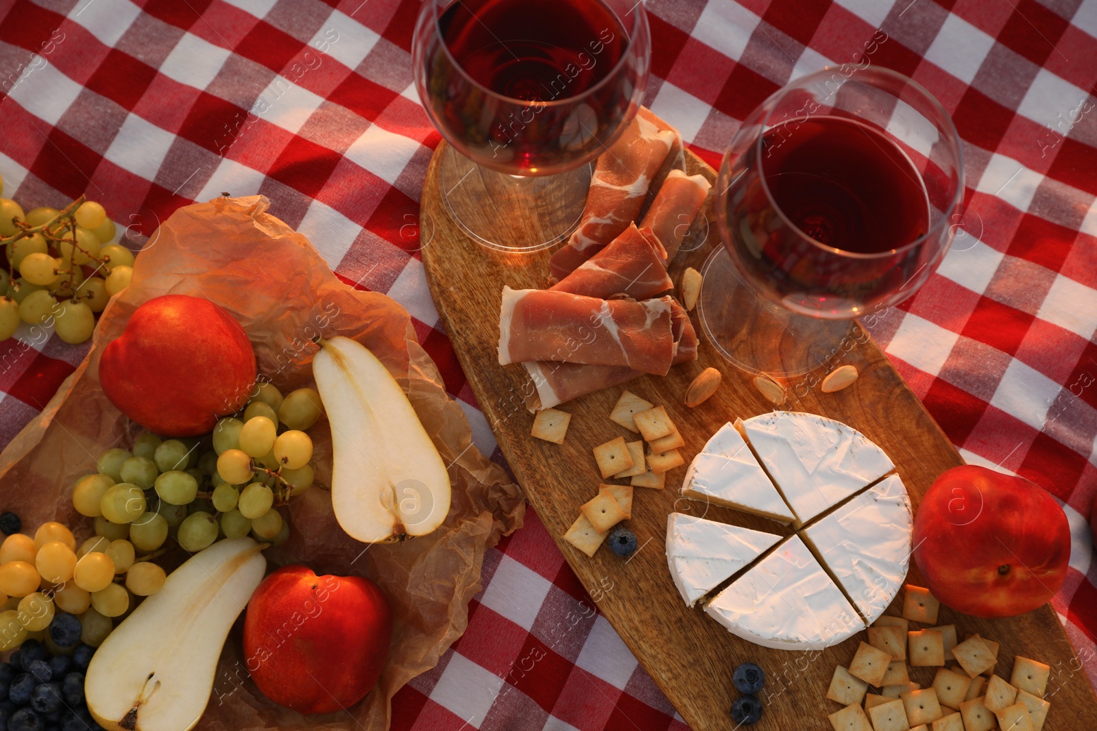 Photo of Wine and snacks on picnic blanket, flat lay