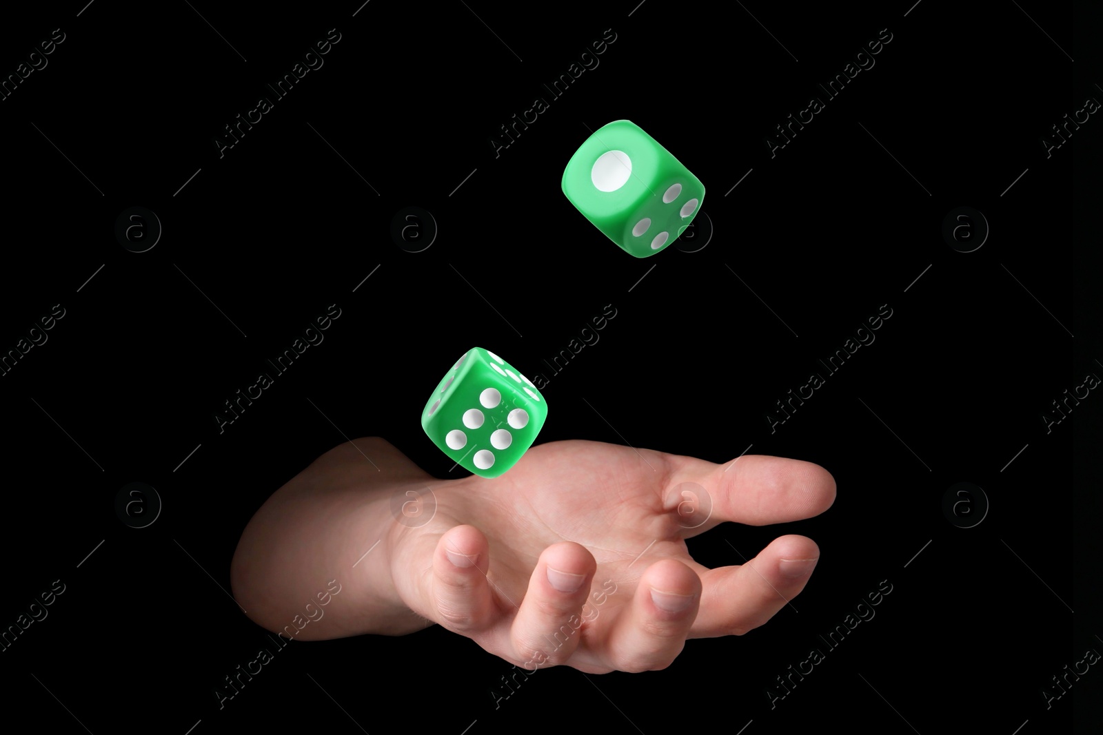 Image of Man throwing green dice on black background, closeup