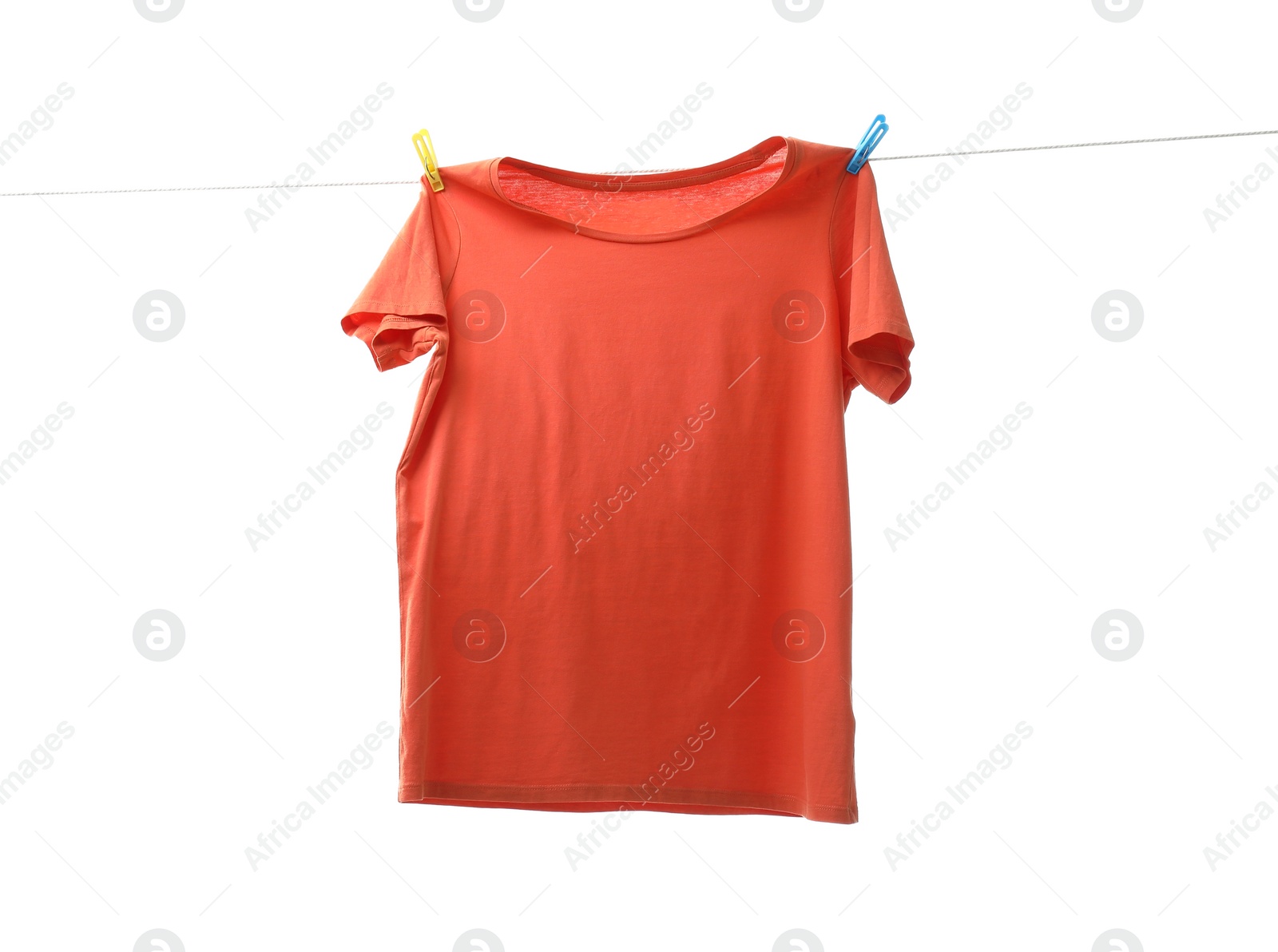 Photo of One orange t-shirt drying on washing line isolated on white