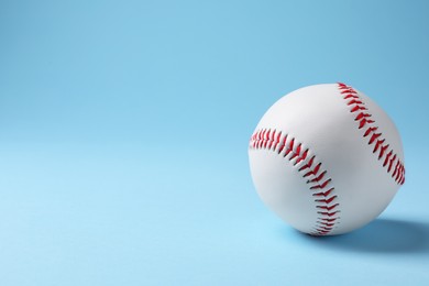 Photo of One baseball ball on light blue background. Space for text